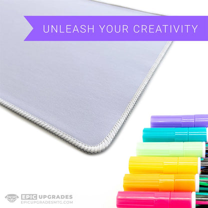 White 17x11 inch sublimation blank mat shown on a desk. Versatile surface works as a large mousepad, placemat, or small playmat. Smooth polyester top with black rubber backing, perfect for crafts, custom designs, and heat press printing. Ideal for personalized gifts, card games, or creative projects.
