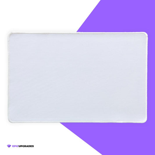 White 17x11 inch sublimation blank mat shown on a desk. Versatile surface works as a large mousepad, placemat, or small playmat. Smooth polyester top with black rubber backing, perfect for crafts, custom designs, and heat press printing. Ideal for personalized gifts, card games, or creative projects.
